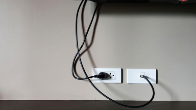 cords hanging against  a wall from a tv
